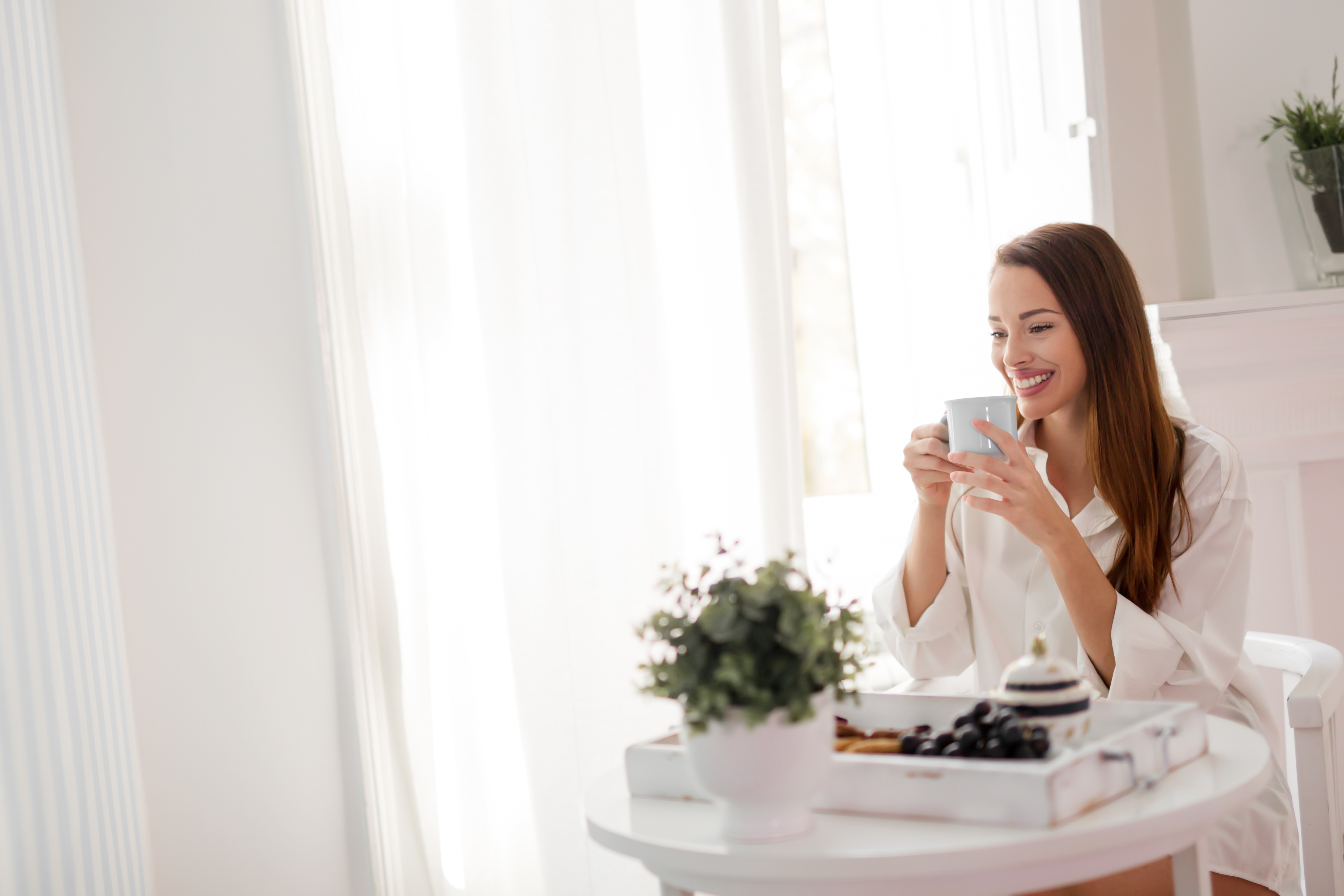 Beautiful woman enjoying morning tea wearing shirt
